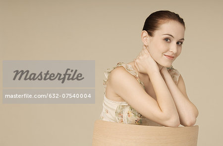 Woman wearing ruffly dress, hair in bun, smiling at camera, portrait