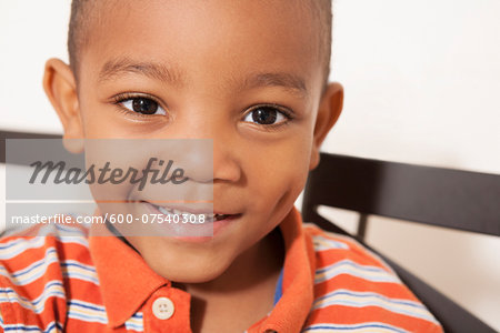 Close-up portrait of African-American boy, smiling and looking at camera, USA