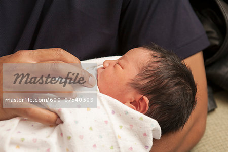 Close-up of father holding newborn baby girl, USA