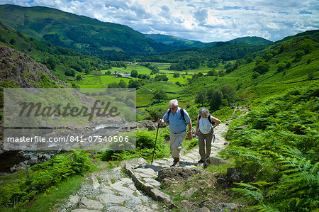 Tourists hill climbing on nature trail in lakeland countryside at Easedale in the Lake District National Park, Cumbria, UK