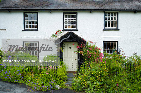 Quaint lakeland cottage with studded front door and Welcome sign, at Troutbeck in the Lake District National Park, Cumbria, UK