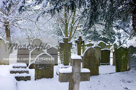 Snow-covered gravestones in Hampstead Parish Graveyard in Church Row and Holly Place in Hampstead, North London, UK