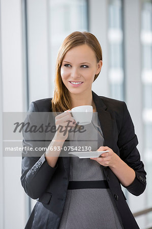 Beautiful businesswoman drinking coffee in office