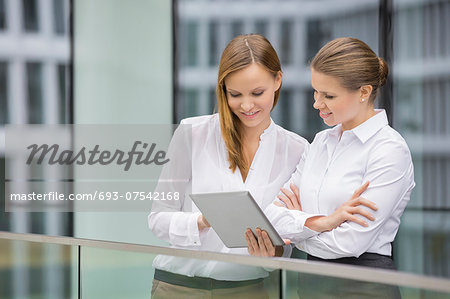 Businesswomen using digital tablet in office Businesswomen using digital tablet in office