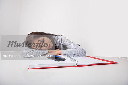 Exhausted businesswoman leaning at office desk