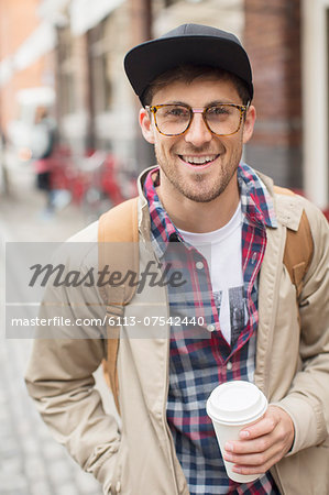 Man with cup of coffee on city street