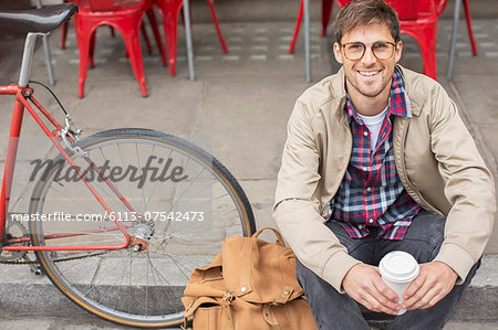 Man drinking coffee on city street