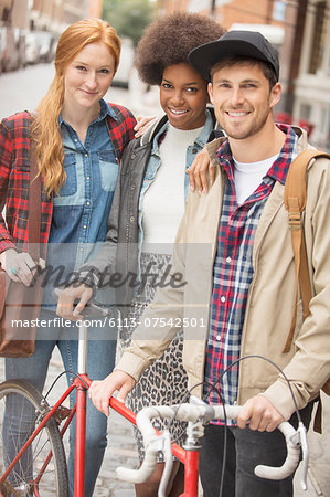 Friends smiling together on city street Friends smiling together on city street