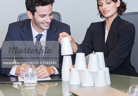 Business people stacking cups in meeting