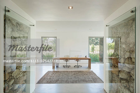 Rocks behind glass in wall of modern home office