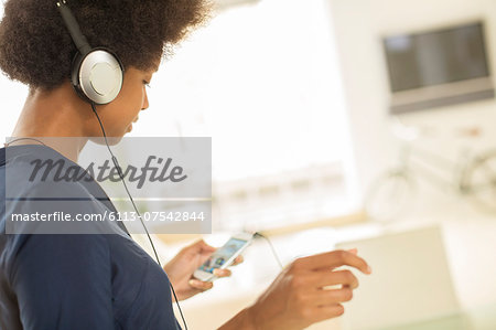 Woman listening to headphones in living room