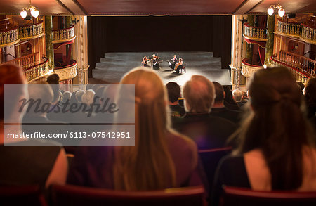 Audience watching quarter perform on stage in theater