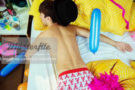 Man sleeping on bed after party