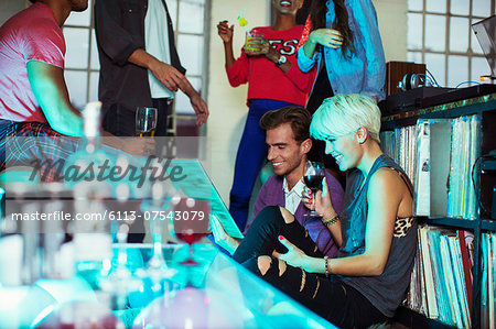Couple looking at records at party Couple looking at records at party