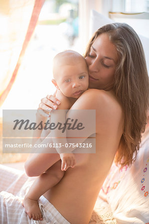 Bare chested mother holding baby boy