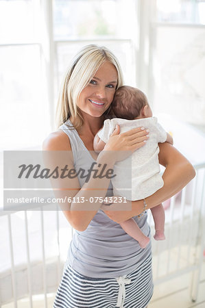 Mother holding baby girl in nursery