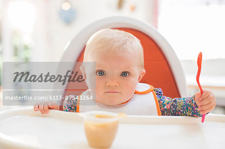 Baby girl eating in high chair