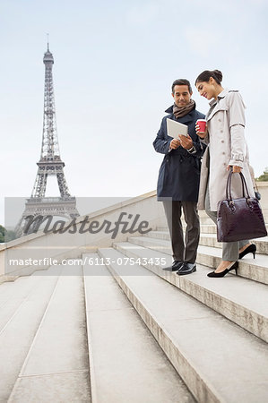 Business people talking on steps near Eiffel Tower, Paris, France