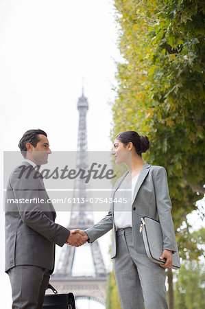 Business people shaking hands near Eiffel Tower, Paris, France