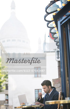 Businessman working at sidewalk cafe near Sacre Coeur Basilica, Paris, France