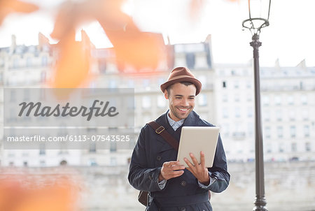 Businessmen using digital tablet along Seine River, Paris, France