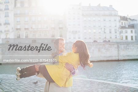 Man holding girlfriend along Seine River, Paris, France