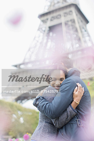 Couple hugging in front of Eiffel Tower, Paris, France