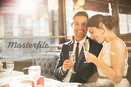 Well-dressed couple drinking champagne in restaurant