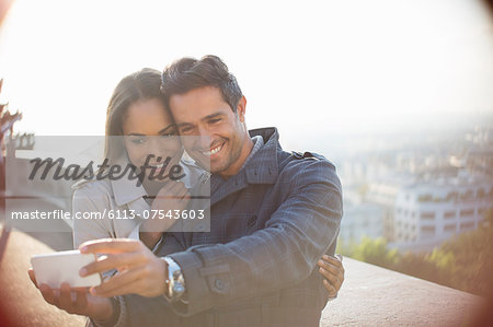 Couple taking self-portrait overlooking city