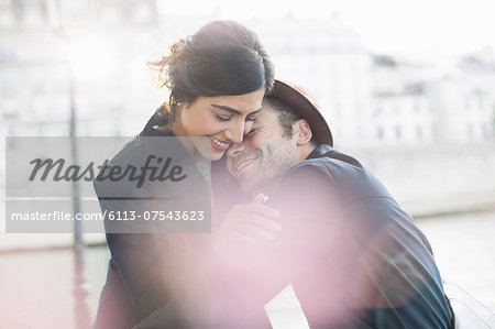 Couple hugging along Seine River, Paris, France