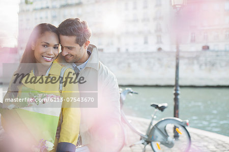 Couple with bouquet of flowers by Seine River, Paris, France