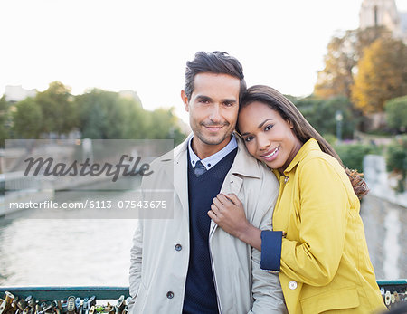 Couple hugging on Pont des Arts bridge over Seine River, Paris, France