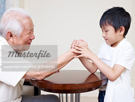 grandpa hand wrestling with grandson.