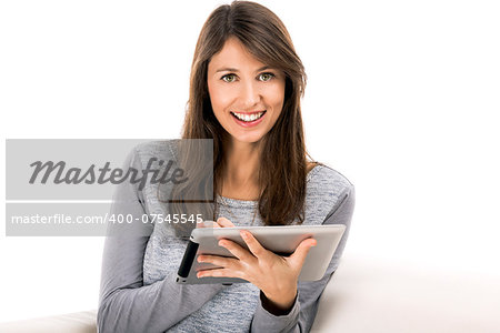 Beautiful woman sitting on the soda and working with a tablet