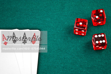 poker card and dice in corner in of a green fabric background