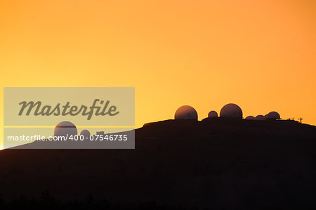 Image of landscapes with silhouette of astronomical observatory at sunset