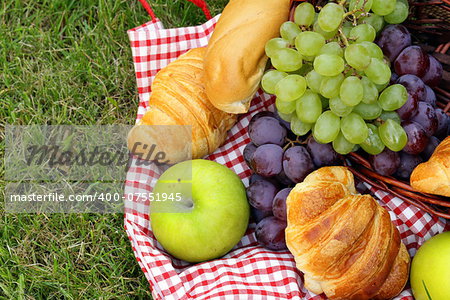 picnic on green grass with grapes and croissants