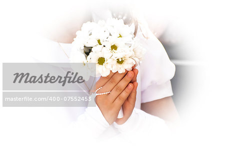 Girl in white dress holding flowers at first holy communion.