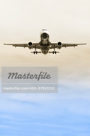 passenger jet on landing approach through a gradient sky