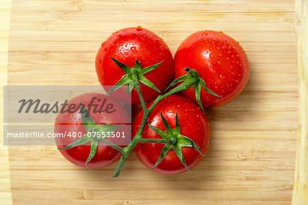 Top view of fresh tomatoes on wooden chopping board