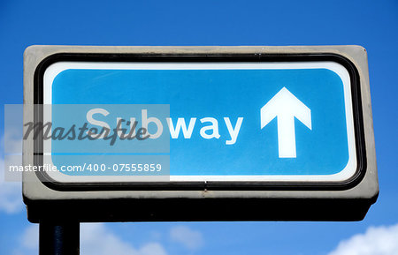 Blue subway crossing sign against the sky in London