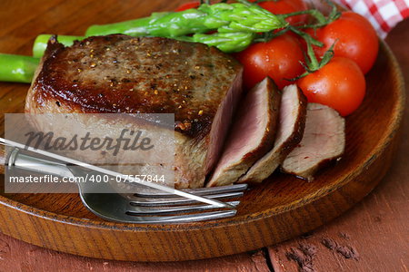 grilled meat beef steak with vegetable garnish (asparagus and tomatoes)