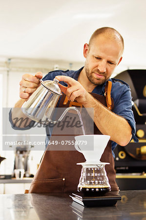 Barista pouring boiling water into coffee filter