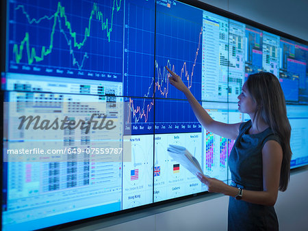 Businesswoman preparing presentation on graphical screens
