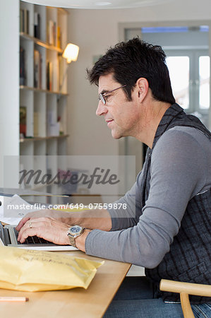 Mature businessman using laptop at home