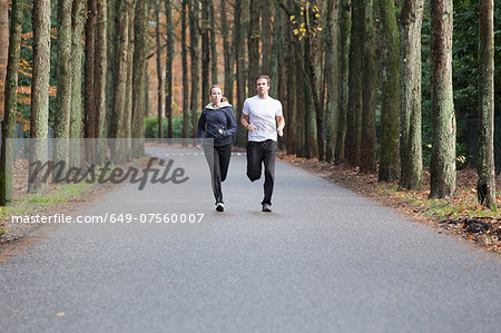 Couple running through forest