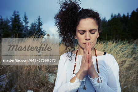 Mid adult woman meditating in forest