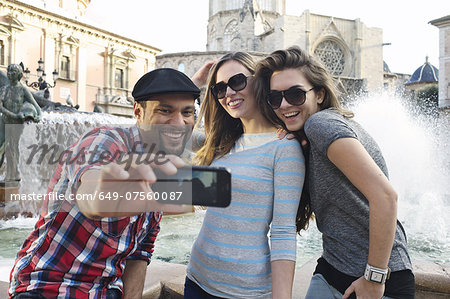 Tourist friends taking self portrait, Plaza de la Virgen, Valencia, Spain