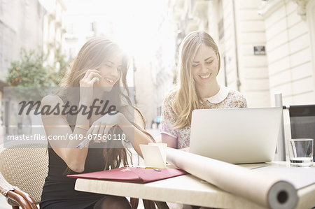 Two young female friends taking a break at sidewalk cafe, Valencia, Spain