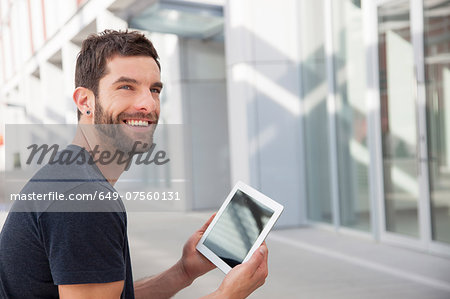 Mid adult man holding digital tablet